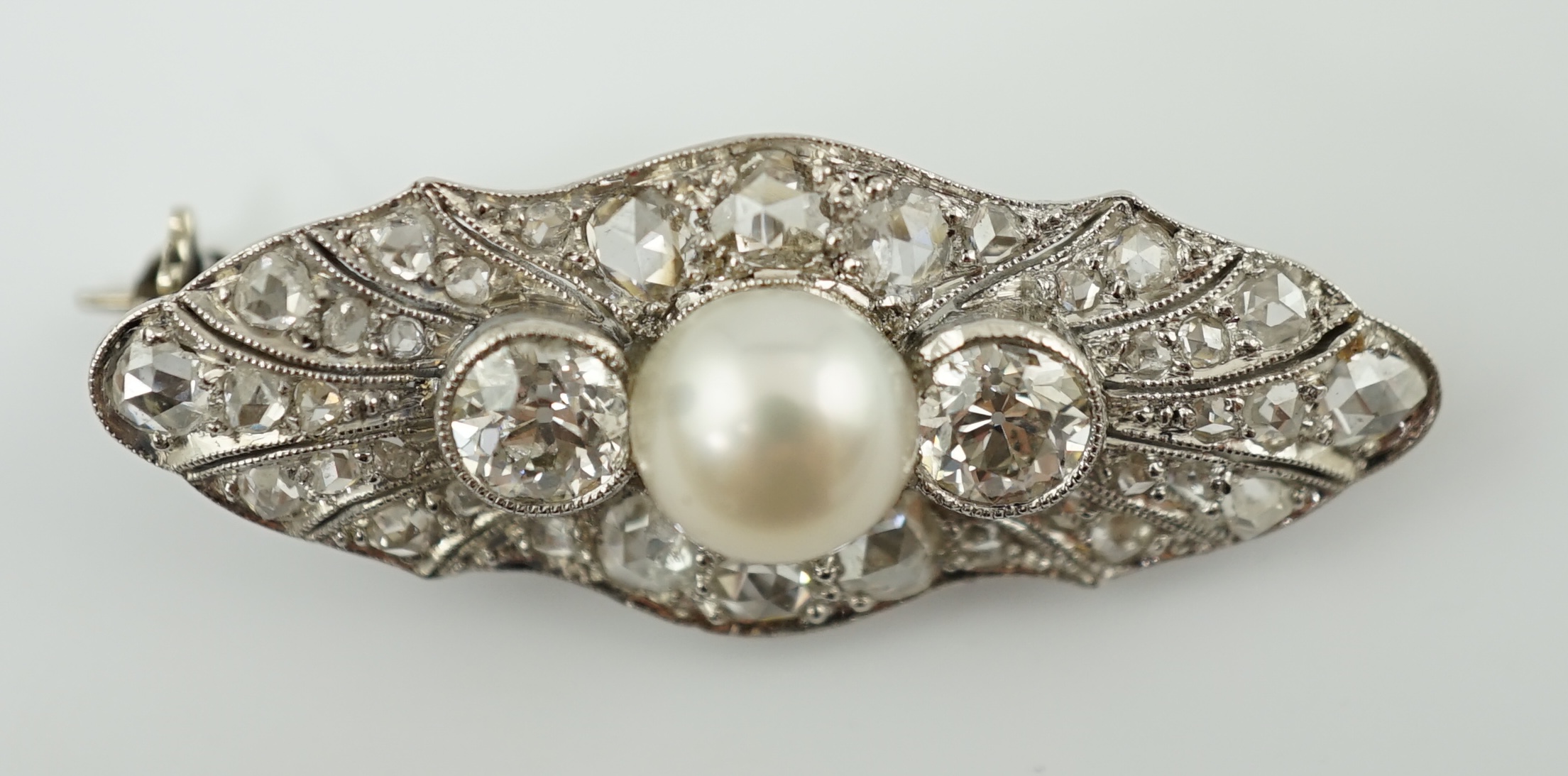 A Belle Epoque white gold, single stone split pearl and millegrain set diamond cluster lozenge shaped brooch